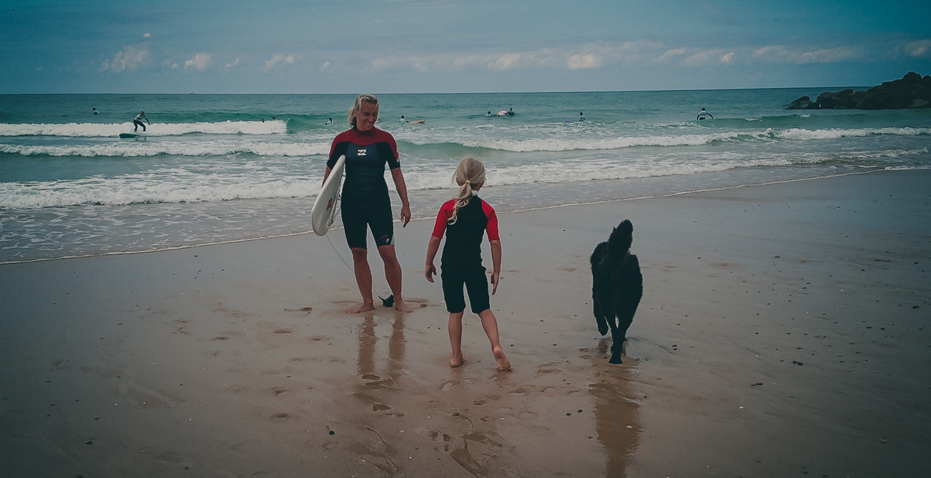 Malaika Loher am Strand mit Tochter und Hund nach dem Surfen